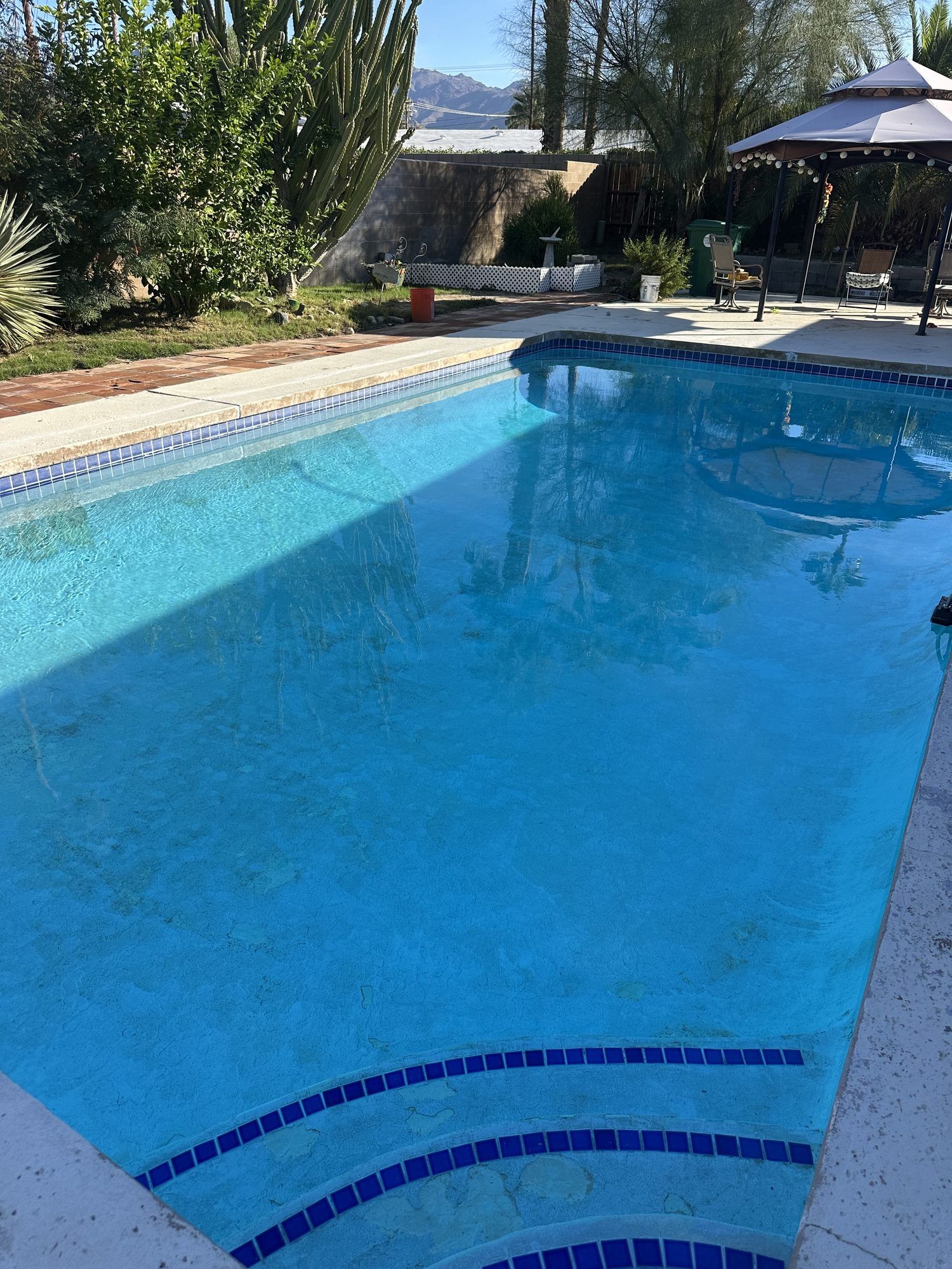 The same pool with clear blue water after cleanup